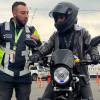 Foto de un hombre en una moto junto a un funcionario de Movilidad. 