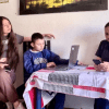 Imagen de una madre de familia con su hijo e hija estudiando en un computador