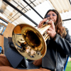 Imagen de una mujer jóven tocando un instrumento músical de viento.