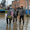 Imagen de tres personas caminando en un charco