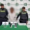Hombre capturado, con material incautado sobre una mesa