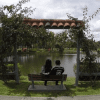 Imagen de una pareja de enamorados sentados en una banca a la orilla del lago en el Parque El Lago de Bogotá