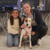 Imagen de una señora con una niña y una perrita recién adoptada