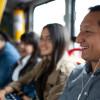 Foto de un hombre en un bus de TransMilenio usando audífonos.