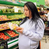 Imagen de una mujer embarazada escogiendo un alimento en un supermercado