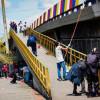 Infractores saldando deuda con ciudad pintando un mural en puente vehicular.