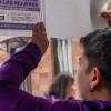 Mujer con un cartel sobre rutas de atención para mujeres víctimas de violencia.