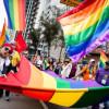 Foto integrantes de comunidades LGBTI con banderas en Bogotá durante una manifestación.