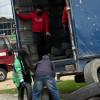Foto que muestra personas subiendo llantas en desuso en un camion 