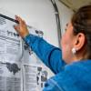 Una mujer pegando información en una pared