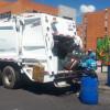 Foto de un camión recolector de basuras y operarios de aseo de LIME en Bogotá.
