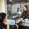 Foto de una mujer y un hombre en una ventanilla de atención de servicios de movilidad en Bogotá.