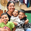 Imagen de una madre sonriendo junto a sus hijos
