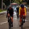 Dos ciclistas pedaleando en Bogotá de noche