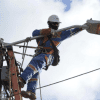 Imagen de un técnico de ENEL realizando mantenimiento en un poste de luz.