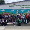 Estudiantes, comunidad y funcionarios frente al mural del Día de la Tierra