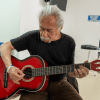 Foto de una persona mayor tocando guitarra 