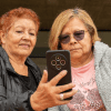 Imagen de dos mujeres adultas mayores viendo un celular