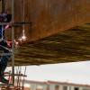 Foto de obreros realizando trabajos en un puente vehicular en Bogotá.