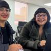 Dos mujeres sonriendo y estudiando