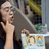 Imagen de una profesora con un libro en el que se ve una ilustración