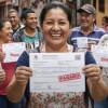 Personas sonriendo mostrando su recibo de pago del impuesto predial