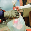 Imagen de una persona entregando una bolsa de basura a un recolector.