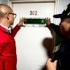 Imagen de un funcionario y un policía colocando el aviso de sellado