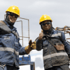 Imagean de dos trabajadores de la obra del Metro de Bogotá vestidos con su uniforme.