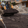 Imagen de un frente de obra vial con dos trabajadores parchando una calle