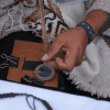 Imagen de unas manos que están trabajando en una artesanía en cuero.