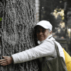 Foto de un hombre abrazando un arbol 