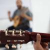 Foto que muestra una persona sosteniendo una guitarra