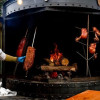 Foto de un hombre frente a un asador de carnes en Bogotá.