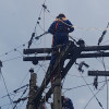 Foto que muestra personas con el uniforme de Enel Colombia realizando trabajos en un poste de luz