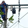 Foto que muestra dos personas con uniforme de Enel Colombia en un poste de luz