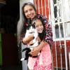 Imagen de una mujer abrazando a una niña que está cargando a un gato.