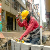 Foto que muestra un hombre martillando en el piso 