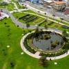 Vista aérea parque urbano de Bogotá con lago circular senderos áreas verdes y viviendas