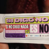 Mano de mujer sosteniendo un volante que dice: "Si digo no o no digo nada, es no. Llama a la Línea Púrpura".