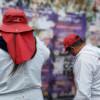 Dos defensores del espacio público retirando publicidad política ilegal del espacio público.