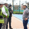 Foto que muestra cuatro personas con casco blanco hablando en un parque