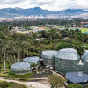 Imagen panorámica del Tropicario del Jardín Botánico de Bogotá José Celestino Mutis con vista a la ciudad, cerros y cielo nublado.