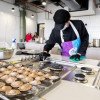Persona prepara empanadas en aula culinaria del CEFE Cometas de Suba con estufas, bandejas y utensilios educativos