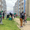 Foto que muestra un grupo de personas barriendo un camino peatonal
