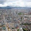 Vista aérea de Bogotá con edificaciones densas, vías principales y cielo nublado