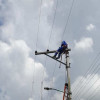 Foto que muestra una persona con el uniforme de Enel Colombia trabajando en un poste de energía 