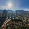 Vista panorámica de Bogotá con vista a edificios, montañas, cielo despejado y sol intenso