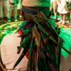 Imagen de señor de espalda con banda de plumas en ritual de fuego 
