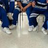 Estudiantes de colegio sentados en sillas.